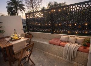 a patio with a bench and a table and lights at Oasis Costa del Silencio - Large Pool & Relax in Costa Del Silencio