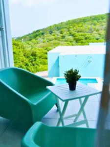 a green chair and a table with a plant on a balcony at Santirome Studio 2 - Cozy Westpunt Escape for Two in Westpunt +27 photos