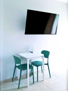 a white table with four chairs and a tv at Santirome Studio 2 - Cozy Westpunt Escape for Two in Westpunt