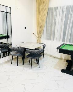 a dining room with a ping pong table and pool tables at Dinems Apartment in Ikeja