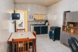 a kitchen with a table and a stove and a table and chairs at Casa Celeste in Boa Vista