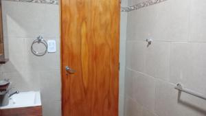 a wooden door in a bathroom with a sink at Altos de la Villa House in Concepción del Uruguay +9 photos