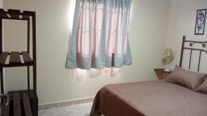 a bedroom with a bed and a mirror and a window at Altos de la Villa House in Concepción del Uruguay