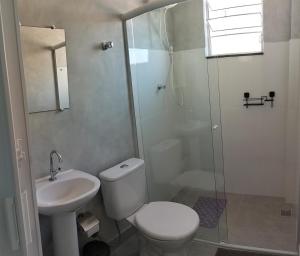 a bathroom with a toilet and a sink and a shower at Kitnet Moderna com Ar, Garagem e Wi-Fi Rápido in Votorantim