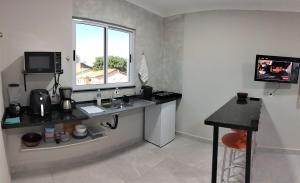 a kitchen with a sink and a window in a room at Kitnet Moderna com Ar, Garagem e Wi-Fi Rápido in Votorantim