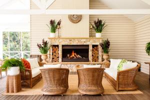 a living room with a fireplace and wicker chairs at Nightcap Ridge - Byron Bay Hinterland in Dorroughby