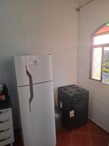 a kitchen with a white refrigerator and a stove at Confort Suite 01 in Contagem