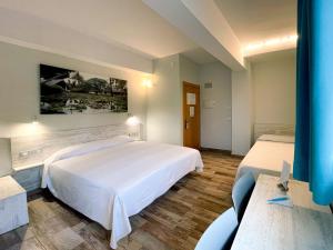 a hotel room with two beds and a painting on the wall at Te Maná Hotel in Torreblanca