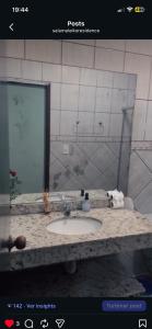 a bathroom counter with a sink and a mirror at Residêncial Allah in Peruíbe +14 photos