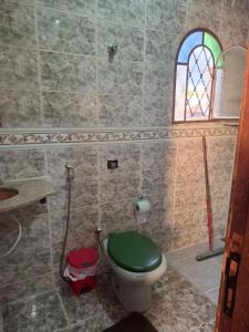 a bathroom with a green toilet and a window at Confort Suite 01 in Contagem +9 photos