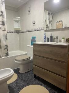a bathroom with a toilet and a sink and a tub at Cataleya Apartment in Cullera +39 photos