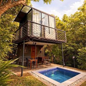 a tree house with a balcony and a swimming pool at abot langit calatagan in Calatagan