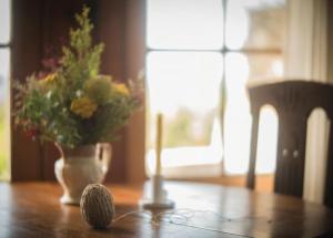 a ball of yarn sitting on a table with a vase of flowers at Devlin's Cottage in Cape Bridgewater +46 photos