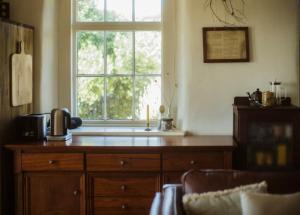 a kitchen with a window and a wooden dresser at Devlin's Cottage in Cape Bridgewater