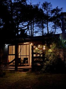 a cabin with a hammock in the yard at night at Monoambiente en Valizas in Barra de Valizas