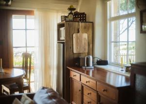 a kitchen with a refrigerator and a table and window at Devlin's Cottage in Cape Bridgewater