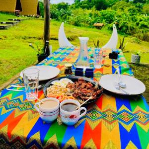 a table with a plate of food on a colorful table cloth at abot langit calatagan in Calatagan