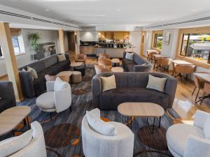 a lobby with couches and tables and a bar at Millennium Hotel Rotorua in Rotorua