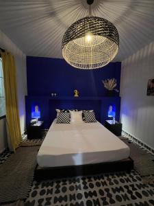a bedroom with a large bed and a chandelier at Riad OUAR - Once Upon A Riad in Marrakesh +30 photos