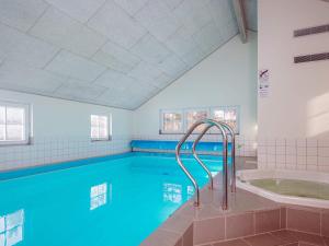 a large swimming pool with a tub in a room at 14 person holiday home in Blåvand in Blåvand