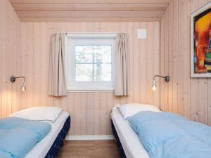 two beds in a room with a window at 14 person holiday home in Blåvand in Blåvand +33 photos