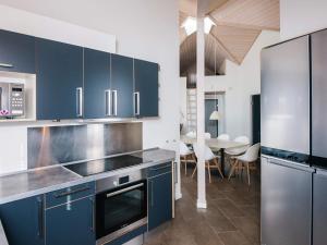 a kitchen with blue cabinets and a dining room at 14 person holiday home in Blåvand in Blåvand