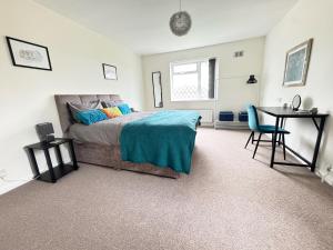 a bedroom with a bed and a desk and a table at Very Spacious 4 Bedroom house with large garden in Leamington Spa