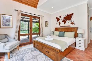 a bedroom with a bed and a chair and a window at Standen Manor, Hunter Valley Country Estate & Stables in Belford +32 photos