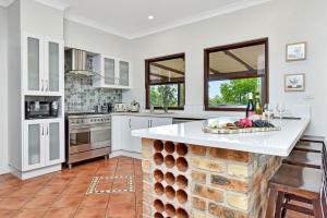 a kitchen with white cabinets and a counter top at Standen Manor, Hunter Valley Country Estate & Stables in Belford