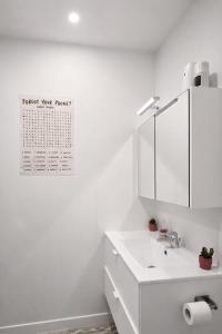 a white bathroom with a sink and a mirror at cozy studio Brussels airport in Steenokkerzeel +5 photos
