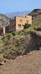 ein Gebäude, das auf einem Hügel neben einem Gebäude steht in der Unterkunft Azadne in Oulad Akkou