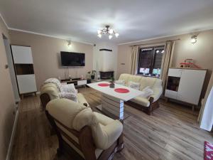 a living room with a couch and a table and chairs at MiiG Residence Jacuzzi & Sauna Zator Oświęcim in Oświęcim