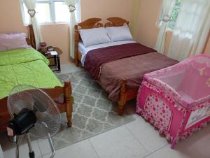 a bedroom with two twin beds and a fan at Daniel's comfort in Canefield
