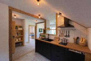 a kitchen with black cabinets and a counter top at apartamentwroznowiepl in Rożnów