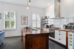 a kitchen with white cabinets and a counter top at Altitude Apartment in Martinborough