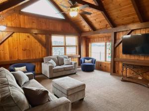 a living room with couches and a flat screen tv at Fox's Den Your Lakefront Escape with Dock and Stunning Views in Rocky Mount