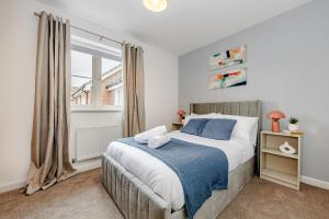 a bedroom with a large bed and a window at Modern 2 Bedroom House in Cheshunt in Cheshunt