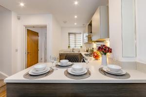 a kitchen with a table with plates and bowls on it at Modern 2 Bedroom House in Cheshunt in Cheshunt
