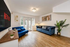 a living room with a blue couch and a table at Modern 2 Bedroom House in Cheshunt in Cheshunt
