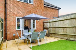 a table and chairs with an umbrella on a patio at Modern 2 Bedroom House in Cheshunt in Cheshunt