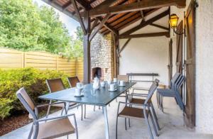 a table and chairs on a patio with a fireplace at Gîte Nolan in Saint-Mesmin