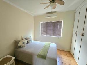 a bedroom with a bed and a ceiling fan at Schuilhoek Farm House at Ngweni Private Game Farm in Hluhluwe +75 photos