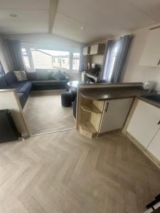 a living room with a couch and a table and a mirror at Moonstone in Lossiemouth