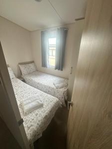 a small room with two beds and a window at Moonstone in Lossiemouth