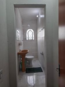 a bathroom with a sink and a toilet at Suite confort 02 in Contagem