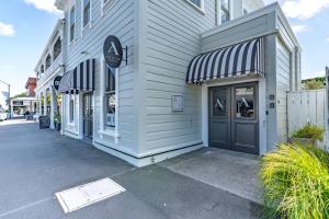 a white building with a door on a street at Altitude Apartment in Martinborough +44 photos