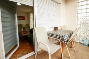 a dining room with a table and chairs on a balcony at BGD Rentals in Donji Milanovac
