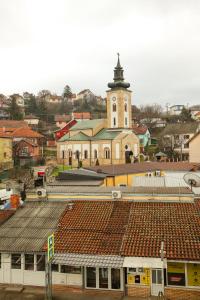 a large building with a clock tower in a town at BGD Rentals in Donji Milanovac
