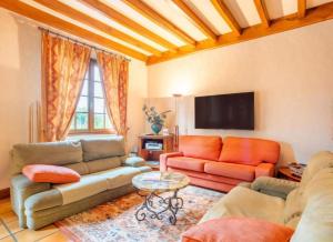 a living room with two couches and a tv at Gîte Nolan in Saint-Mesmin