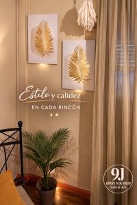 a sign on a wall with a plant in a room at Apart 9 de julio in Salta